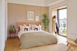 Woman looking out of window in bedroom
