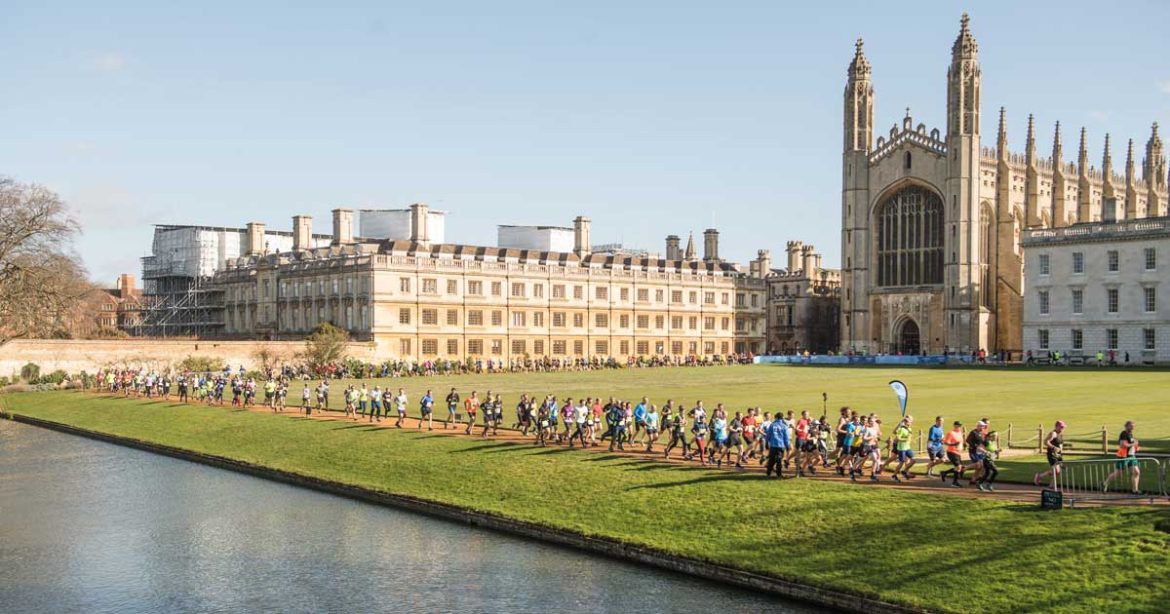 People running along the river through the grounds of King's College Chapel